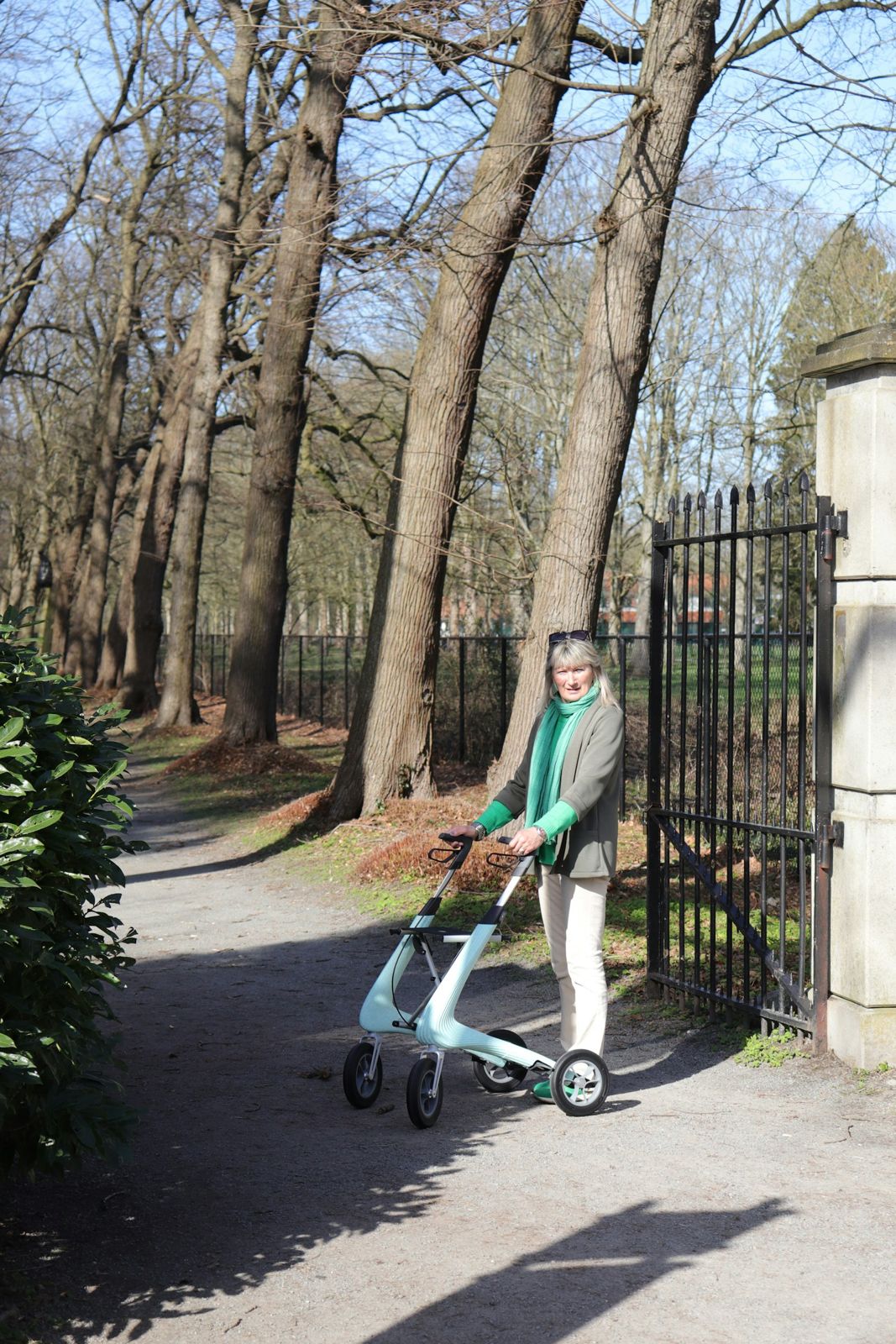 An older person walking with a rollator