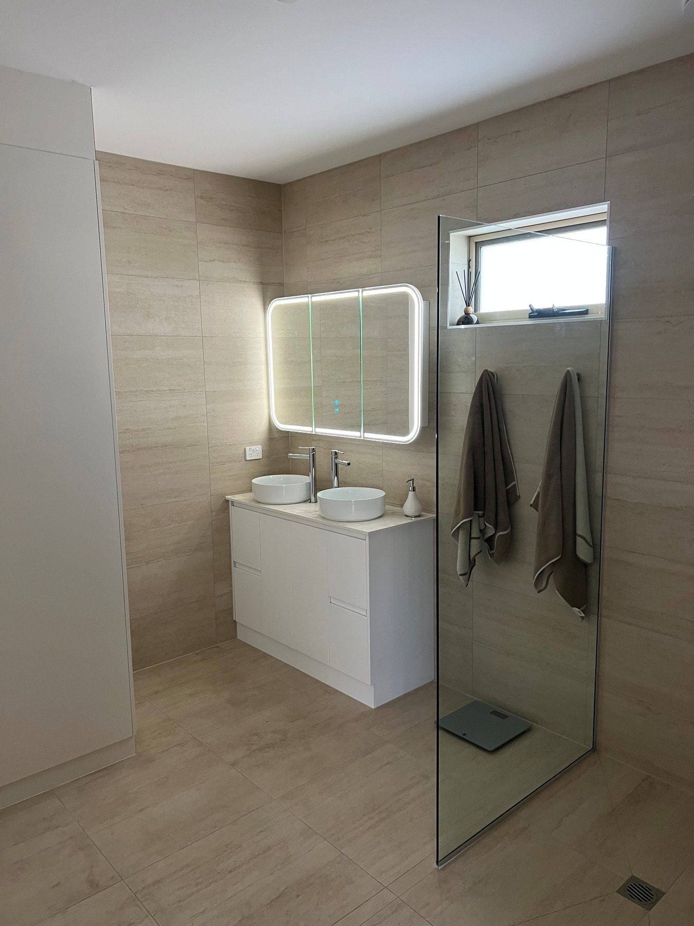 A wet-area bathroom with a frameless screen and wall-hung vanity